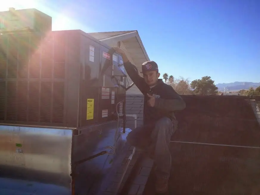 HVAC technician performing Boiler Repair on a rooftop unit in Logan